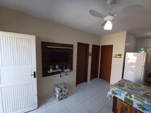 a living room with a ceiling fan and a table at Excelente casa na praia em Matinhos PR. 600 metros da praia. in Matinhos