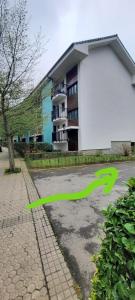 una flecha verde en un estacionamiento junto a un edificio en Donostia Green+Parking, en San Sebastián
