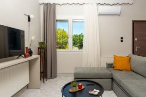 a living room with a couch and a tv at Old Town Apartment in Volos