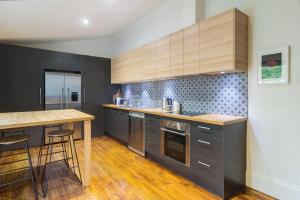 a kitchen with gray cabinets and a wooden counter top at Blackbird at Arlos Glenelg South in Glenelg