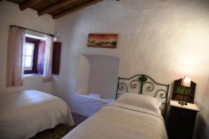 una camera da letto con due letti e una finestra di Quinta de Evoramonte a Estremoz Altre 29 foto