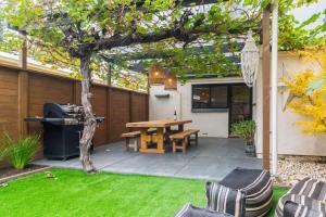 a backyard with a wooden table and a tree at Blackbird at Arlos Glenelg South in Glenelg +14 photos