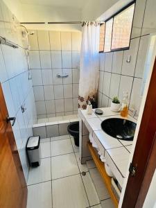 a small bathroom with a sink and a shower at Qouyllur House in Marcará