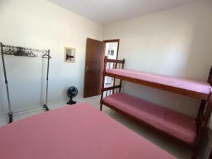 a room with two bunk beds and a pink rug at Excelente casa na praia em Matinhos PR. 600 metros da praia. in Matinhos
