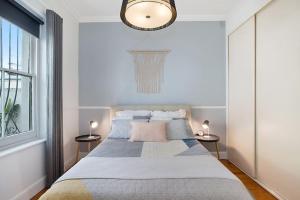 een slaapkamer met een groot bed en 2 bijzettafels bij Renovated cottage in CBD with Backyard in Adelaide