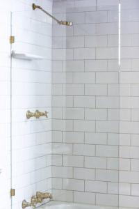 een douche met twee kranen en een wastafel in de badkamer bij Renovated cottage in CBD with Backyard in Adelaide