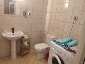 a bathroom with a toilet sink and a washing machine at Warsaw Apartment Iwona - all 45m2 - close to the centre in Warsaw