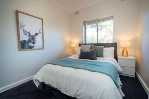 - une chambre dotée d'un lit avec une photo de cerf sur le mur dans l'établissement Clouds on Francis North Adelaide, à Bowden