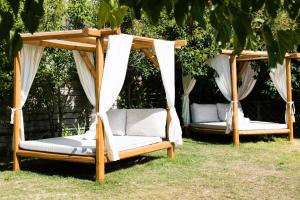 two gazebos in the yard with white curtains at Georgia's Garden by Omilos Hotels in Amoudara Herakliou