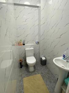 Un baño blanco con inodoro y lavabo. en 2 room apartment Цум Айчурок, en Bishkek
