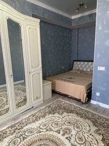 Un dormitorio con una cama, un armario y una alfombra. en 2 room apartment Цум Айчурок, en Bishkek