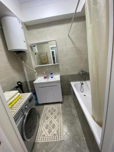 Un baño con lavadora y lavadora. en 2 room apartment Цум Айчурок, en Bishkek