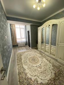 Habitación grande con alfombra grande en el suelo en 2 room apartment Цум Айчурок, en Bishkek