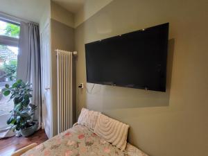 a bedroom with a flat screen tv on the wall at De Doorgang in Groningen