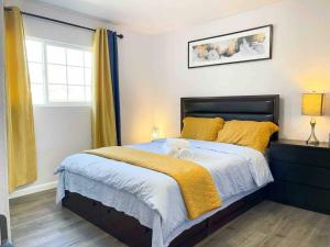 1 dormitorio con 1 cama con sábanas amarillas y ventana en NEW 3BR/2BA house SJ Silicon W/D parking en San José