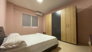 um quarto com uma cama e um armário de madeira em Anna´s apartament em Lushnjë
