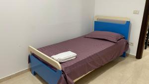 a small bed in a room with a blue bed frame at Anna´s apartament in Lushnjë +5 photos
