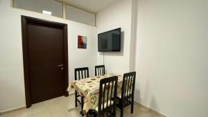 uma sala de jantar com uma mesa e cadeiras e uma televisão em Anna´s apartament em Lushnjë