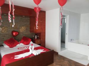 1 dormitorio con 1 cama con almohadas rojas y globos en HOTEL BOUTIQUE LUXURY, en Cali