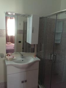 a bathroom with a sink and a glass shower at B&B Giorgio La Pira in Santa Maria Del Focallo