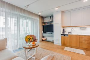 a living room with a table and a kitchen at Little Monaco - Yacht Park in Gdynia