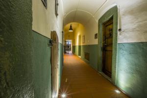 an empty hallway with green walls and a door at Knast-Hotel Fronfeste in Amberg