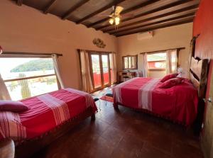 a bedroom with two beds and a large window at Casa Concepcion Suites in Punta Arena