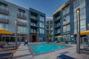 an apartment building with a swimming pool in front of a building at KING BED Modern 2 Bed 2 Bath Pool & Hot Tub in Mountain View