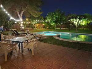 a patio with a table and chairs next to a swimming pool at EL RETIRO in Sanlúcar de Barrameda