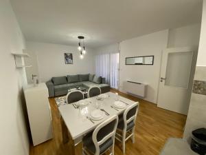 een woonkamer met een tafel en een bank bij R&G apartman in Bijeljina