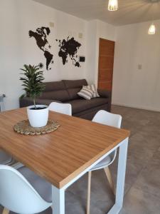 ein Wohnzimmer mit einem Holztisch mit einer Pflanze darauf in der Unterkunft PRISMA CUARENTA in Villa Carlos Paz