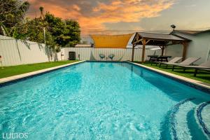 a swimming pool with blue water in a yard at Calle 8 Marvel - Miami Oasis Retreat L55 in Miami