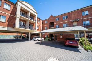 un parking devant un bâtiment en briques dans l'établissement In The Midst on Melbourne, à Adélaïde