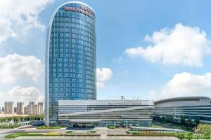 乌鲁木齐乌鲁木齐中建福朋喜来登酒店的一座挂着招牌的高大玻璃建筑