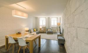 Oporto Welcome Apartments - Ribeira Negra في بورتو: غرفة طعام وغرفة معيشة مع طاولة وكراسي