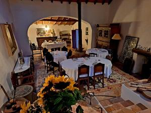 una sala da pranzo con tavoli e sedie bianchi e fiori di Quinta de Evoramonte a Estremoz