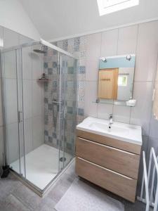 a bathroom with a glass shower and a sink at Domaine Demoiselles Maisonnette in Hauteville