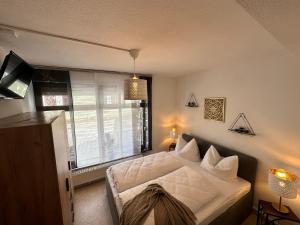 ein Schlafzimmer mit einem weißen Bett und einem Fenster in der Unterkunft Naumburger Charme "Goldener Steiger" in Naumburg