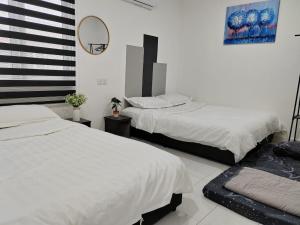 a bedroom with two beds and a mirror on the wall at Kuantan Town Staycation 2R2B@HTAA #Netflix in Kuantan