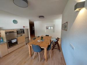 a kitchen and dining room with a wooden table and chairs at Mandla's Hoamat in Umhausen