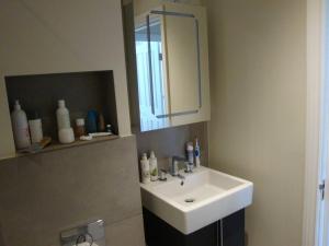 uma casa de banho com um lavatório branco e um espelho. em Luxury Bright & Quiet Flat - Chelsea - Earls Court em Londres