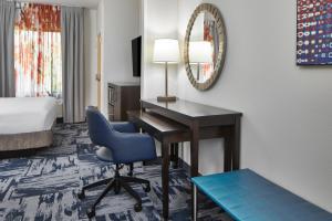 Habitación de hotel con escritorio y silla azul en Fairfield Inn & Suites by Marriott Gainesville, en Gainesville