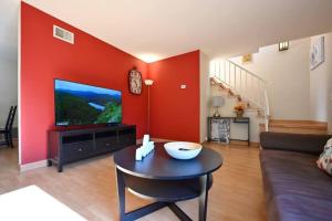 a living room with a red wall with a tv at BIG 2B2.5B townhome in south SJ in San Jose