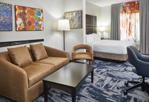 ゲインズビルにあるFairfield Inn & Suites by Marriott Gainesvilleのソファとベッド付きのホテルルーム