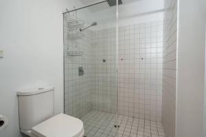 ein weißes Bad mit einer Dusche und einem WC in der Unterkunft Tropicana on Bent Adelaide in Adelaide + 19 Fotos
