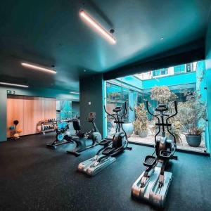 a gym with treadmills and exercise bikes in it at Panoramic view apt with A/C near SJO Airport & Stadium, Cosmopolitan Tower in San José