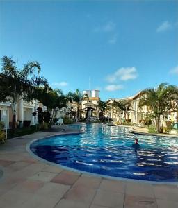 uma piscina num resort com uma pessoa em Recanto Taperapuan Residencial Mont Carmelo em Porto Seguro