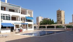 a building with a swimming pool in front of a building at Spacious apartment La Mata pool&beach in Torrevieja