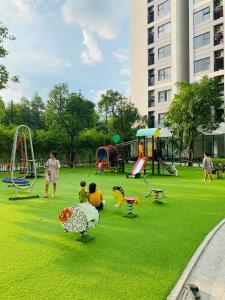 ein Park mit Kindern auf dem Rasen in der Unterkunft Nobita House toà S202 Vinhome Grand Park full nội thất view sông - Netflix in Gò Công