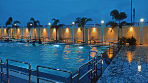 a large swimming pool with people in it at night at Lakshya Resort in Gorakhpur